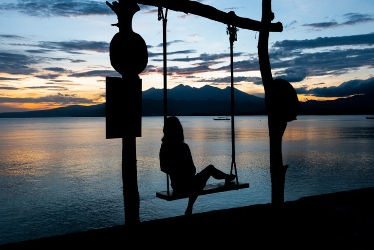 chica disfrutando de una puesta de sol en un lugar tranquilo y paradisíaco. Turismo sostenible. 7 pasos para viajar de forma sostenible. Perder el rumbo
