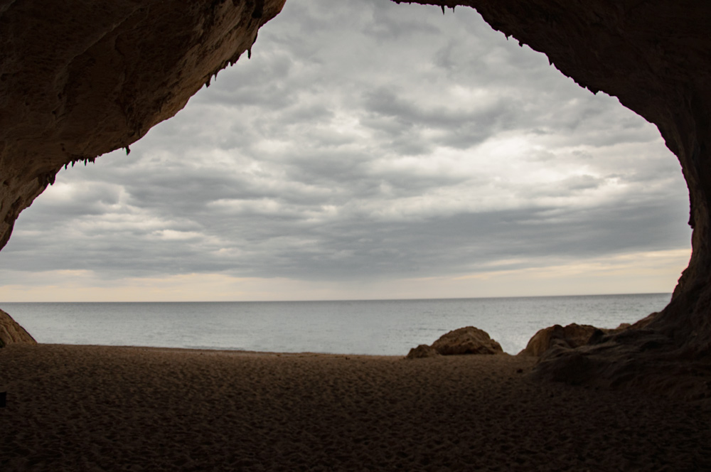 Entrada a la cueva de Cala Luna vista desde dentro de la gruta. Se ve el mar al fondo. La cueva tiene arena en su base. Golfo de Orosei. Cerdeña