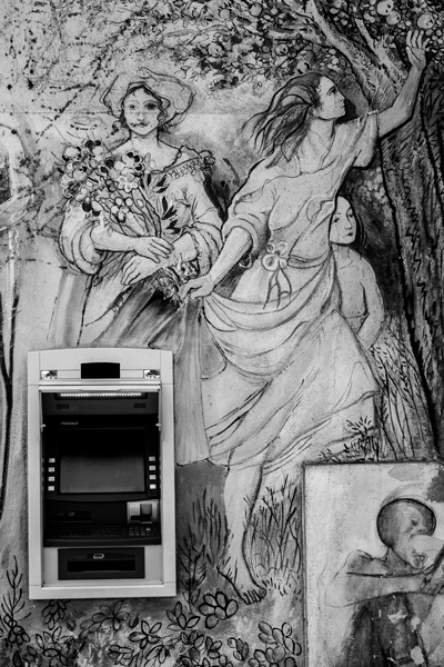 Pintura mural de unas ninfas rodeando un cajero automático del banco. Orgosolo. Cerdeña.