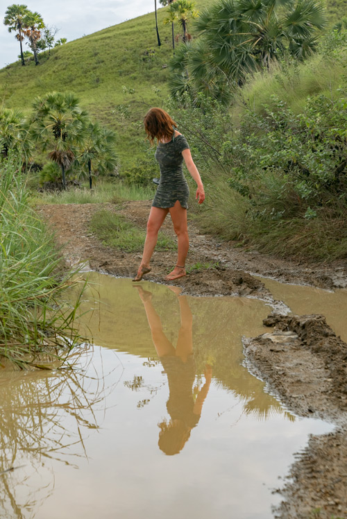 Una chica descalza caminando sobre el barro después de una tormenta. RUTA ISLA DE FLORES. INDONESIA. VIAJE EN MOTO 5 ETAPAS