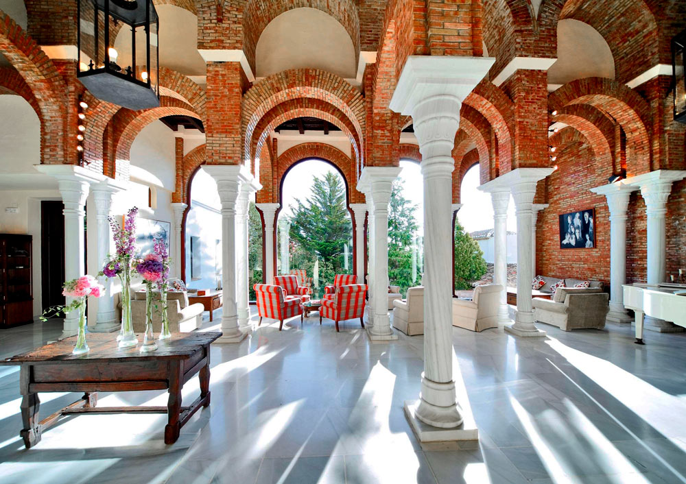 Salón abierto en un patio de columnas de un esplénddo hotel.Alojamientos originales en Andalucía. Perder el Rumbo