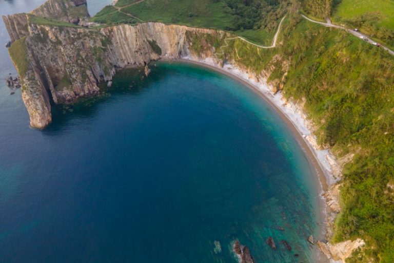 Vista aérea de la playa del Silencio en forma de concha y sus espectaculares acantilados. Playas de Asturias que no debes perderte. Perder el Rumbo