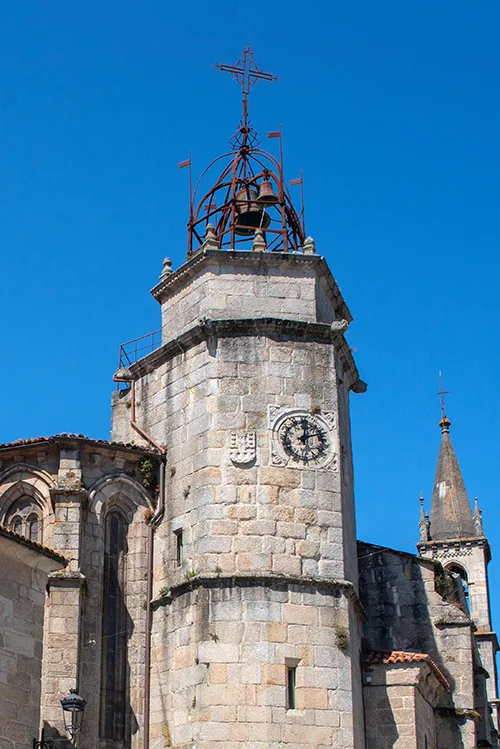 Torre de piedra con un reloj y un campanario en lo alto. 
