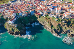 Vista desde el aire de las casas de un pueblo al borde de un acantilado. Cariño. Un pueblo que es puro amor. Perder el Rumbo