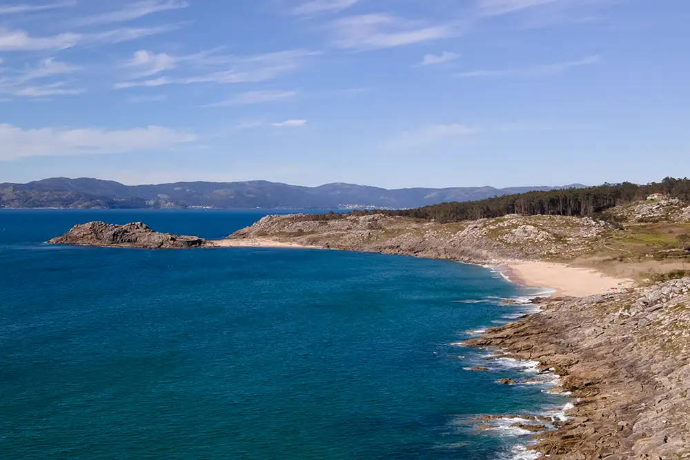 Vista lejana de la playa de Baroña con el castro en la parte izquierda de la foto.
