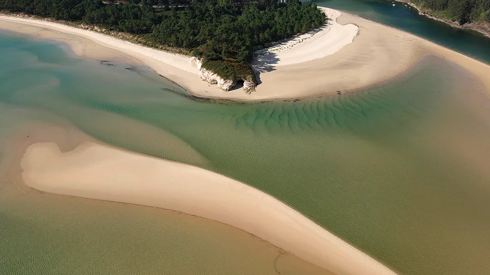 Vista aérea del estuario del Río Sor. La arena y el agua crean formas ondulantes en el suelo. Uno de los puntos más impresionantes de Mañón