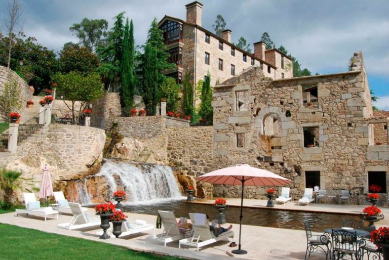 Exterior de un espléndido hotel de piedra con una cascada en el exterior. Hoteles con encanto en Galicia