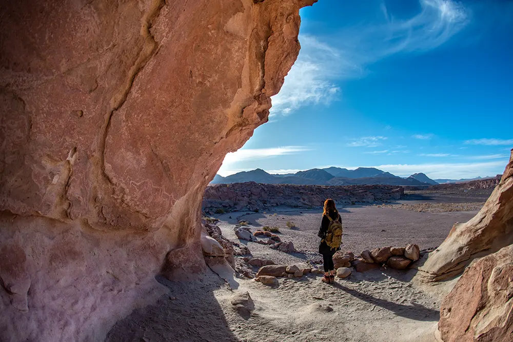 Una persona obserba un conjunto de petroglifos que se encuentran en una pared del asentamiento de Yerbas Buenas, otro de los lugares imprescindibles que ver el el desierto de Atacama. 