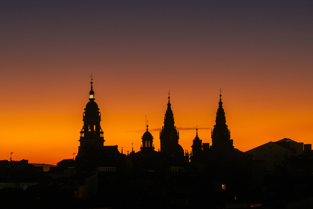 Puesta de sol en Santiago de Compostela. Se ven las torres de la catedral con la luz de la berenguela encendida anunciando el año santo. Curiosidades de Santiago de Compostela, Perder el Rumbo