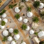 Vista aérea de tiendas de campaña con palmeras a su alrededor. Camping en Tarragona. Perder el Rumbo