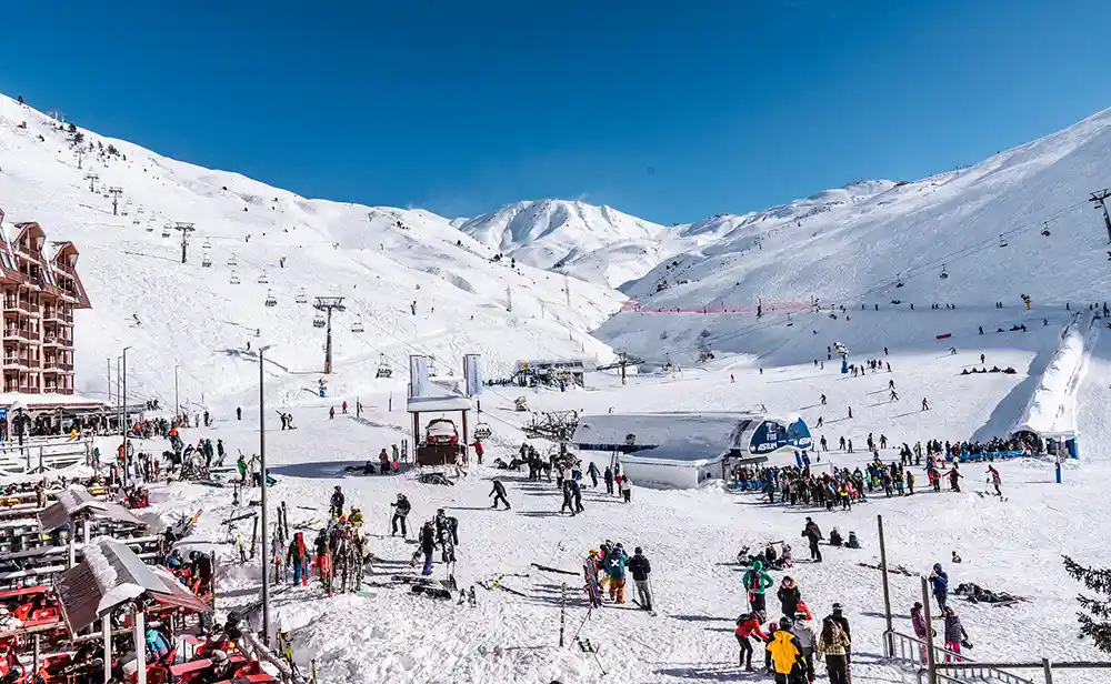 Estación de Candanchú nevada con mucha actividad y gente esquiando.