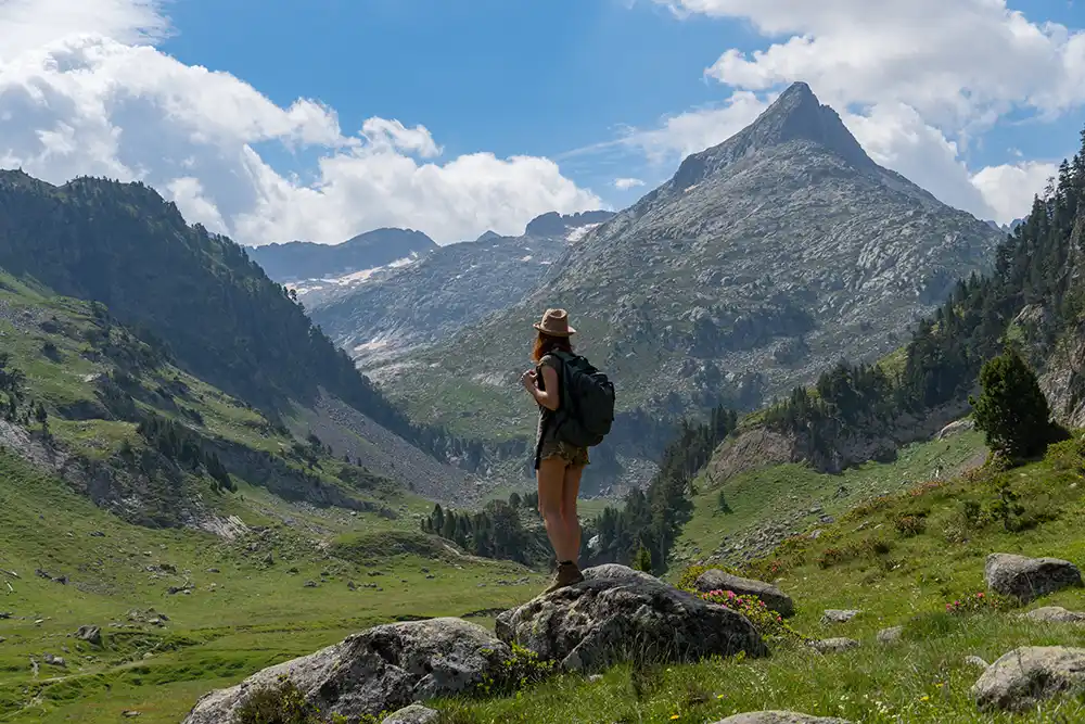Chica contempla el paisaje en la ruta del Forau de Aiugualluts, otro de los lugares imprescindibles que ver en el Pirineo aragonés