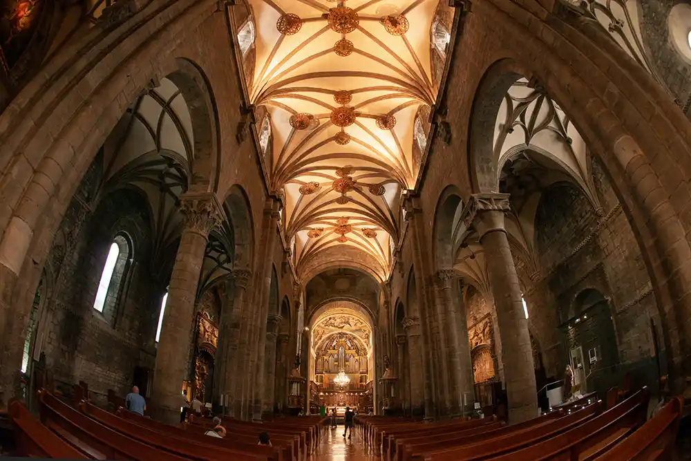 Interior de la Catedral de San Pedro en Jaca con el techo abovedado y pilares en las naves laterales.