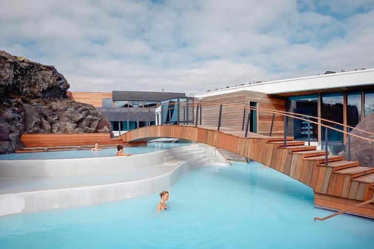 Uno de los hoteles en Islandia con mucho encanto donde podemos ver a una chica dándose un baño en un lago azul turquesa que rodea al hotel