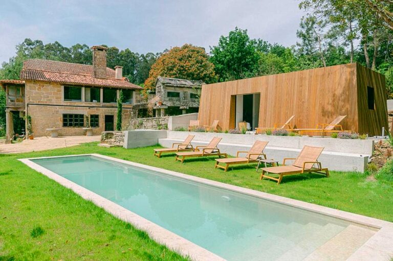 Hotel rústico con una gran piscina en un entorno verde, uno de los mejores hoteles en las Rías Baixas.