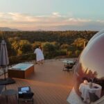 Vista panorámica de uno de los hoteles burbuja en España desde una terraza de hotel burbuja al atardecer en plena naturaleza.