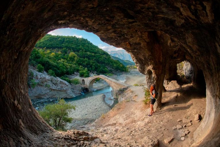 Lucía contempla un puente otomano debajo de una cueva, en las Termas de Benjës, uno de los lugares imprescindibles que ver en Albania.